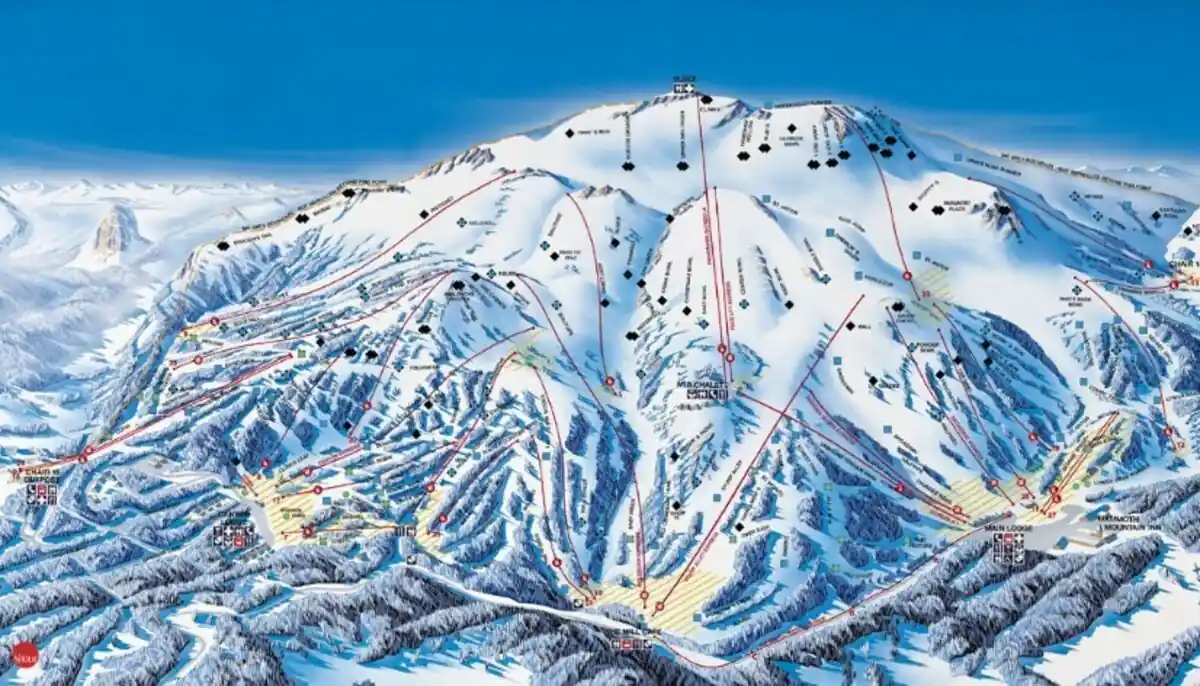 A detailed trail map of a snow-covered mountain ski resort, showing various ski slopes marked with different difficulty levels and ski lifts connecting them. The base area features resort facilities. Surrounding mountains can be seen in the background.
