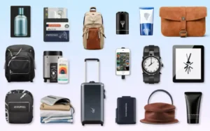 A variety of mens travel essentials including cologne, wallets, backpacks, a suitcase, a watch, a tablet, a phone holder, skincare products, clothing, and a toiletry bag displayed against a light blue background. Travel Essentials for Men